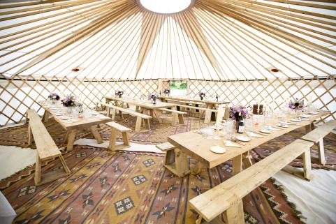 32ft yurt with simple decor and rustic tables